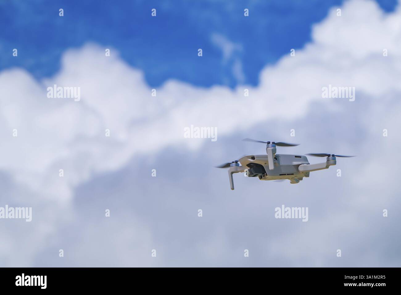 Drone bianco che vola in alto sopra l'isola di siargao, filippine, catturando riprese aeree di un bellissimo cielo nuvoloso durante le vacanze estive Foto Stock