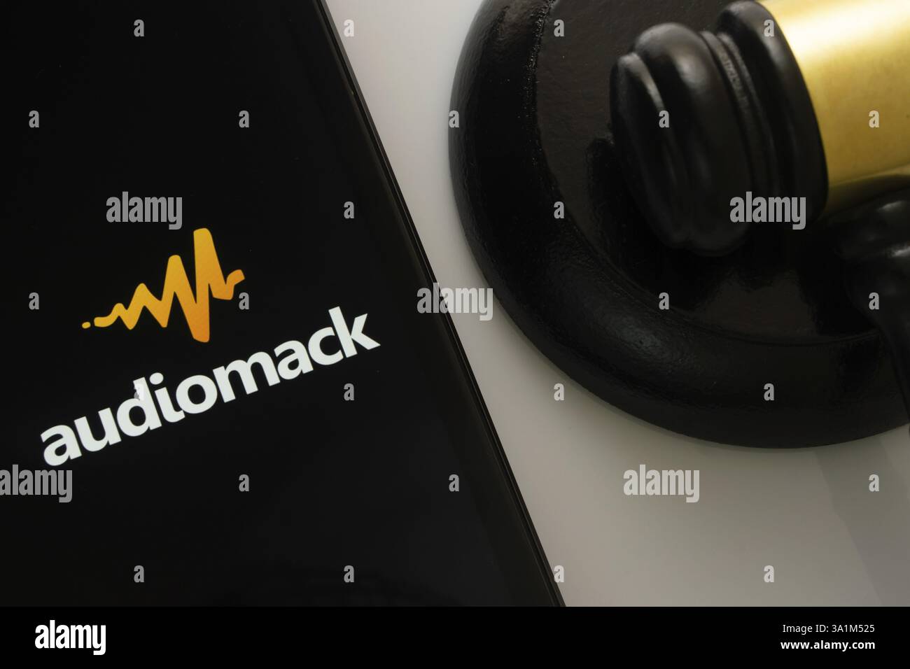 Primo piano dello schermo di un iPad che mostra l'app audiomack accanto al martelletto di un giudice Foto Stock