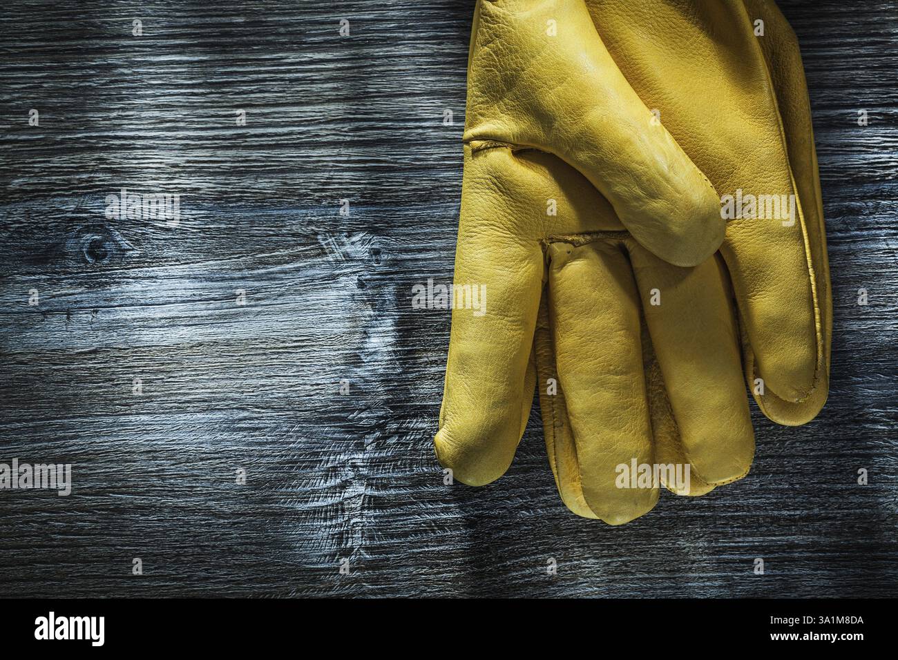Un paio di guanti di sicurezza su tavola di legno Foto Stock Un paio di guanti di sicurezza su tavola di legno Foto Stock