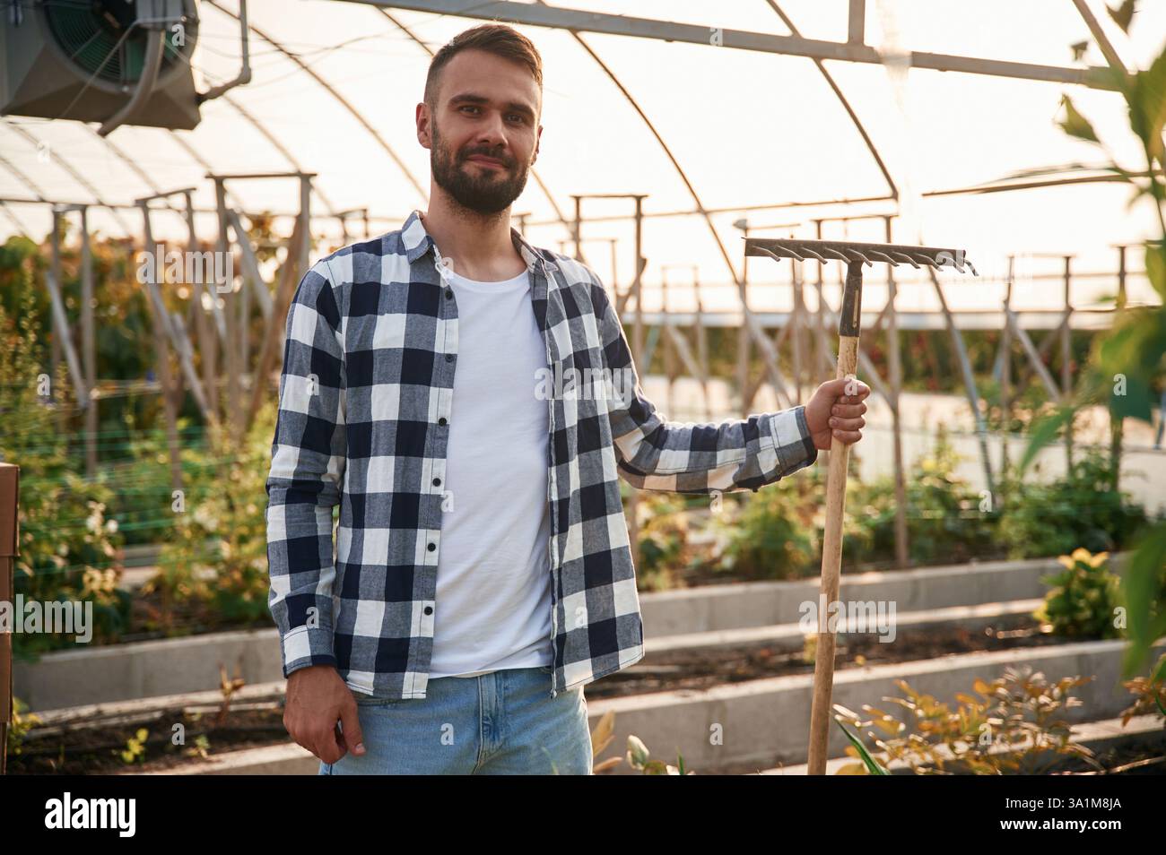 Il giovane giardiniere è nella serra. Foto Stock