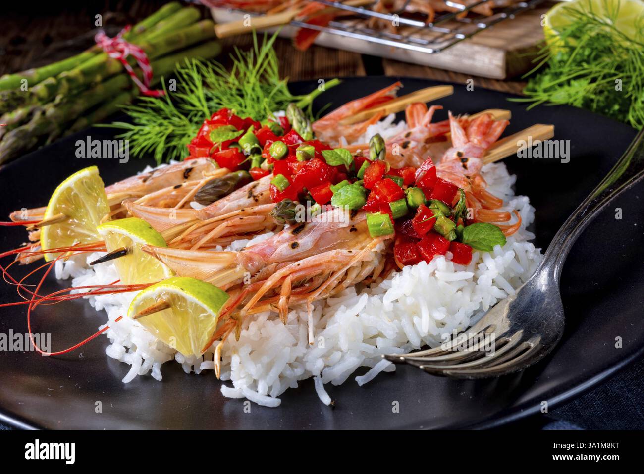Gamberi argentini rossi grigliati con salsa rossa e asparagi verdi Foto Stock