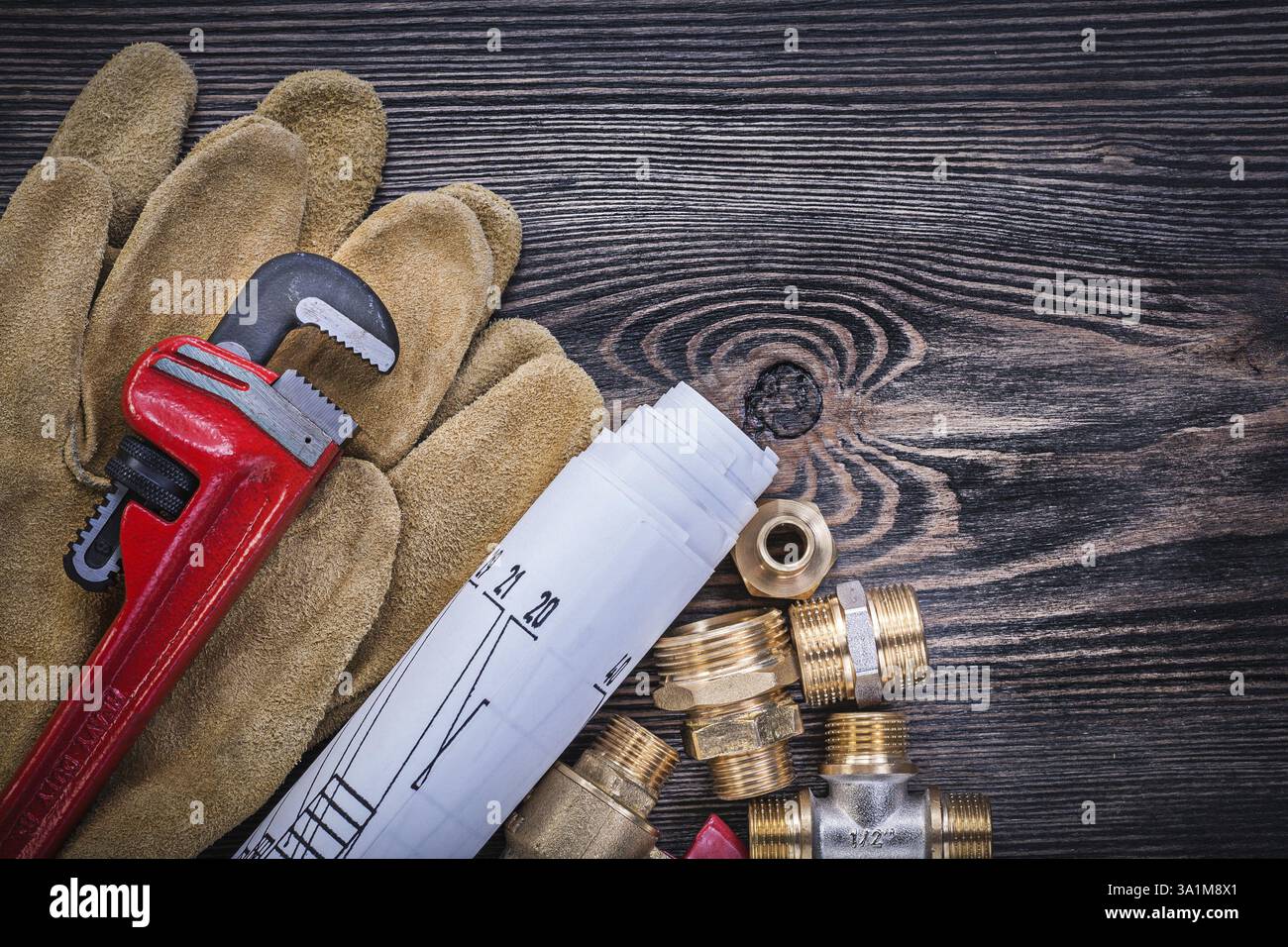 Guanti protettivi disegni costruttivi della chiave per tubi raccordi idraulici in ottone valvola a saracinesca su pannello di legno Foto Stock