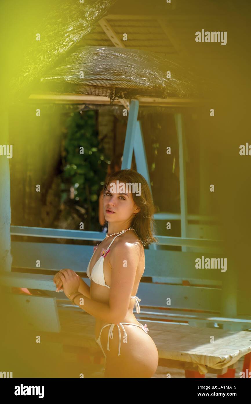 Giovane donna in bikini che prende il sole su una spiaggia tropicale nelle filippine, circondata dalla bellezza dell'isola di siargao e guyam Foto Stock