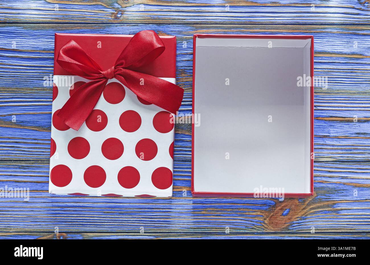 Confezione regalo avvolta in rosso su tavola di legno vintage Foto Stock