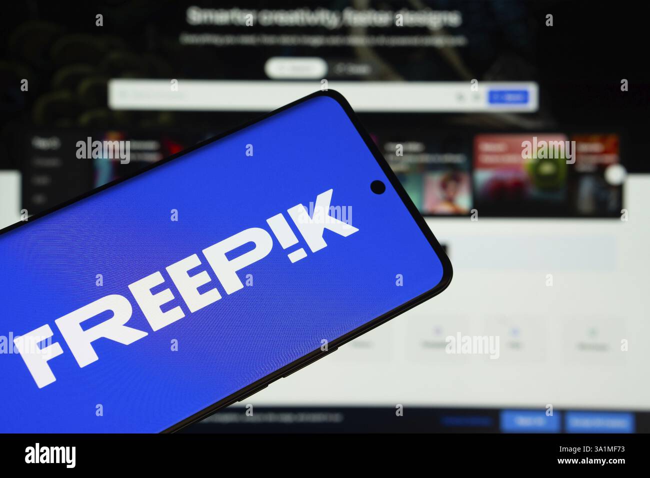 Dhaka, Bangladesh - 8 marzo 2025: Il logo Freepik viene visualizzato sullo schermo di uno smartphone, con il sito web Freepik visibile sullo schermo di un computer Foto Stock
