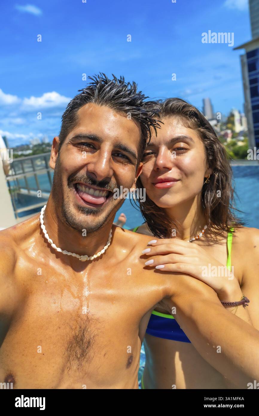I turisti si godono le vacanze estive in piscina, catturando gioiosi selfie sullo sfondo vibrante della città di cebu, filippine Foto Stock