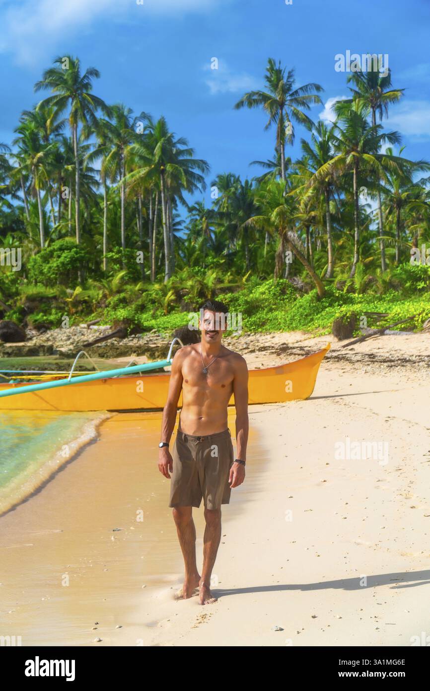 Giovane che si gode le vacanze estive, cammina su una spiaggia tropicale nell'isola di cawhagan, siargao, filippine Foto Stock