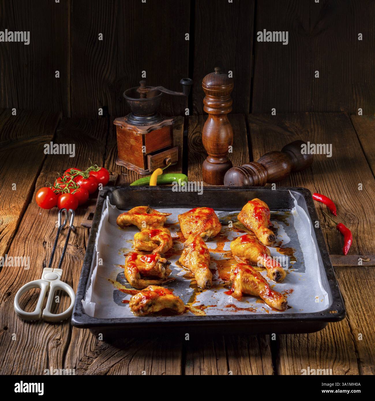 Ali di pollo rustiche e gambe sul vassoio da forno Foto Stock