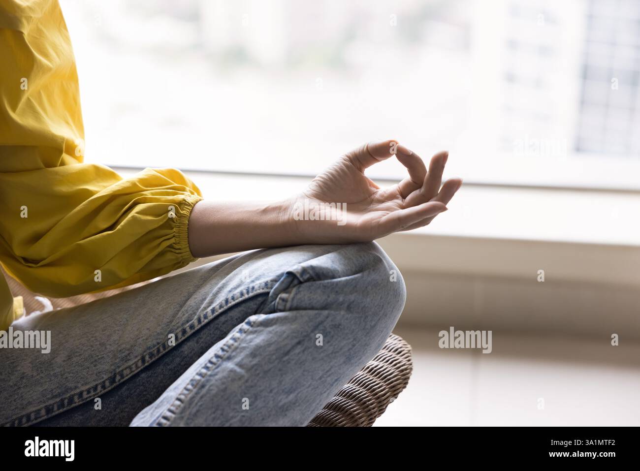 Primo piano, donna seduta in posizione di loto che pratica meditazione Foto Stock