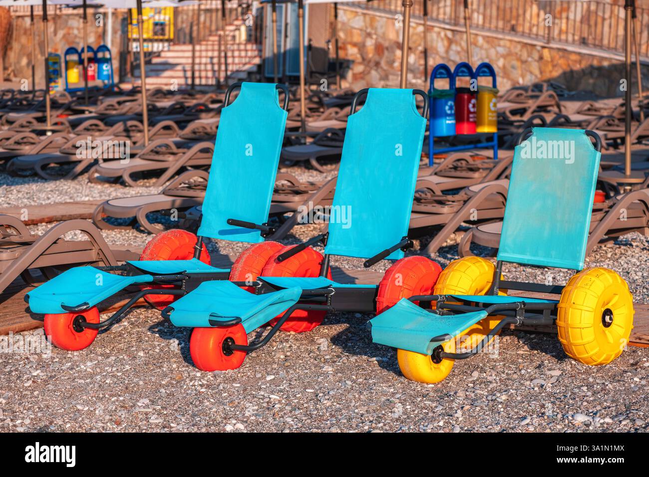Le sedie a rotelle galleggianti sono in piedi su una spiaggia di ciottoli, offrendo ai disabili l'opportunità di godersi il mare e la sabbia con l'indipendenza A. Foto Stock
