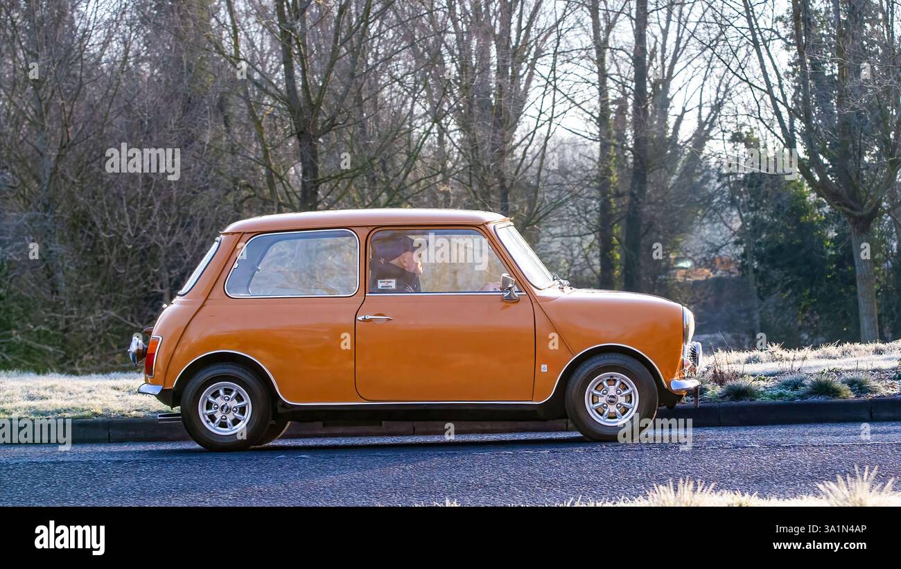 Stony Stratford, Regno Unito - 2 marzo 2025: 1975 Mini auto d'epoca gialle su una strada britannica. Foto Stock