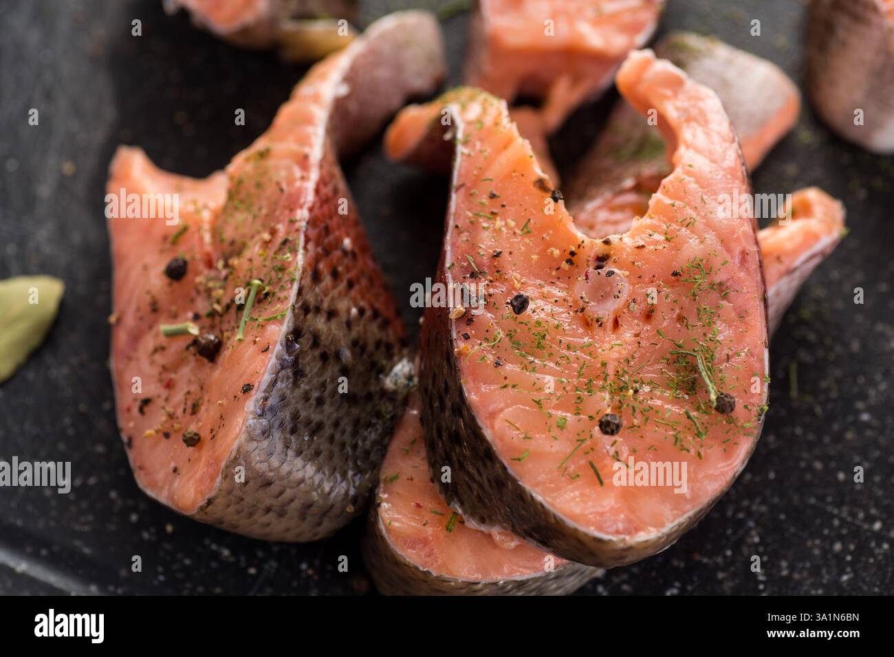 Pezzi crudi di pesce rosso con condimenti. Foto Stock