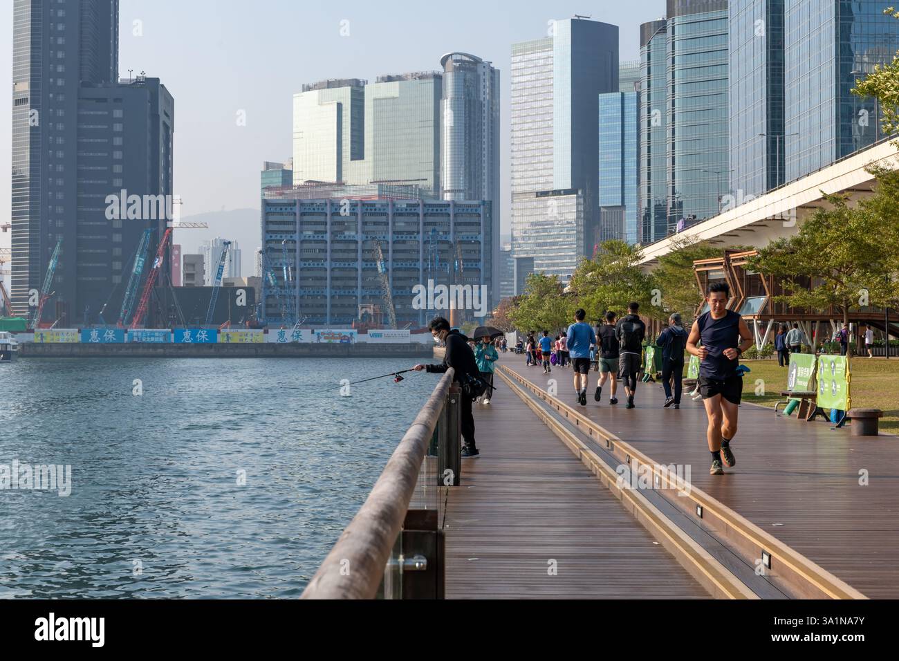 Hong Kong. Cina- 02.15.2025. Gli abitanti del luogo possono praticare attività ricreative sulla passeggiata Kwun Tong in una bella giornata di sole. Foto Stock