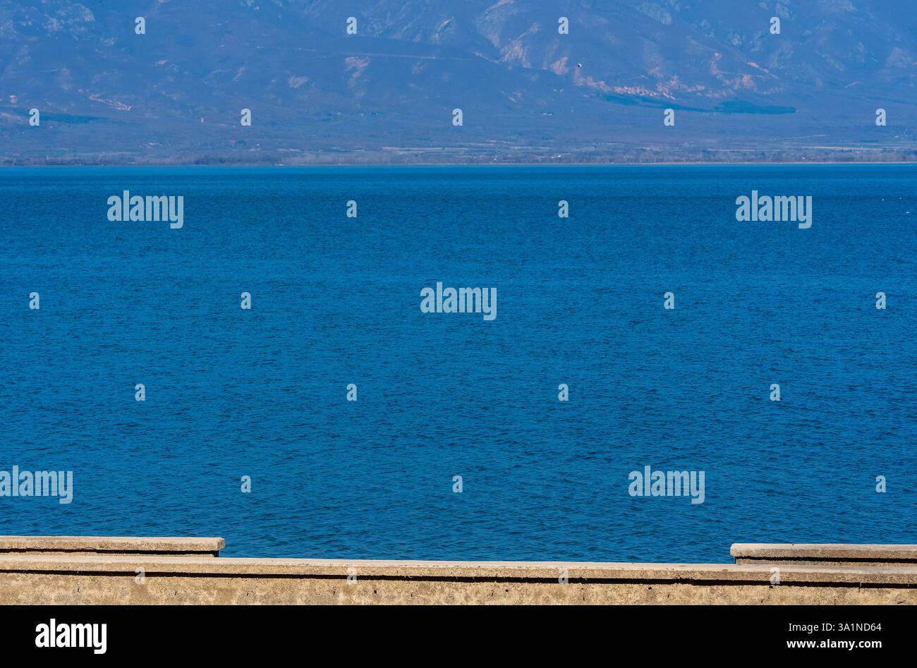 Tranquil Horizon: Lago, sole, collina e cielo Foto Stock