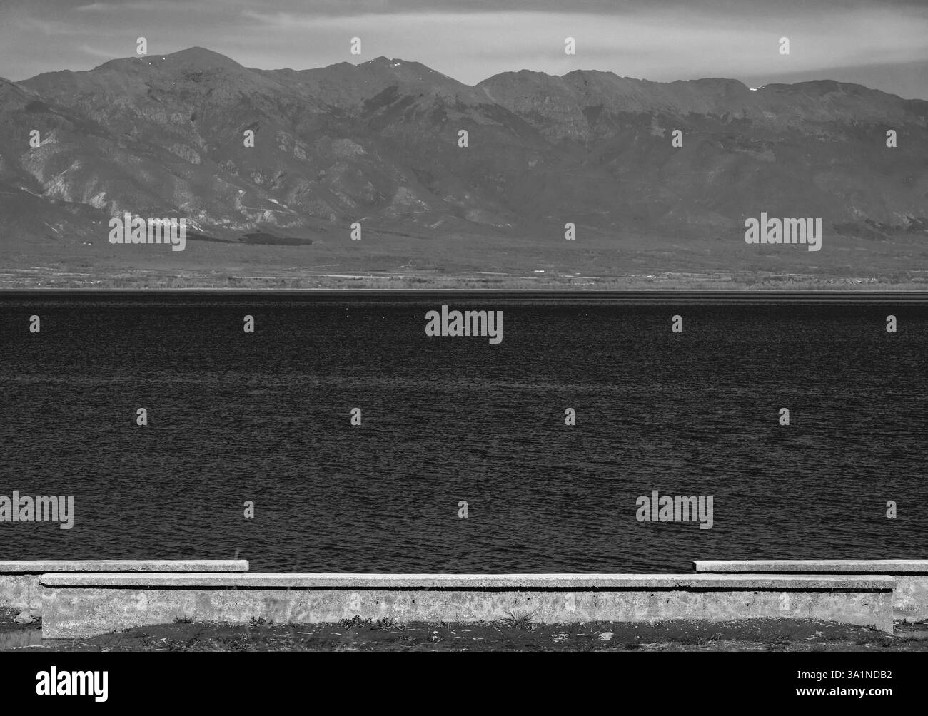 Tranquil Horizon: Lago, sole, collina e cielo Foto Stock