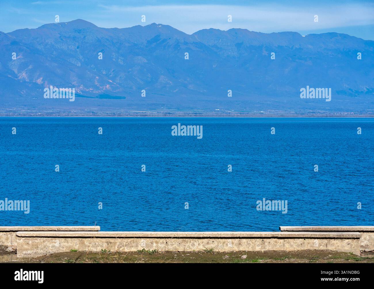 Tranquil Horizon: Lago, sole, collina e cielo Foto Stock