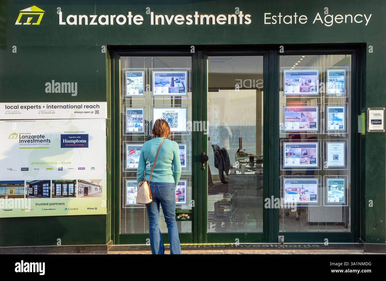 Donna inglese che guarda in una finestra di agenti immobiliari a Playa Blanca sull'isola spagnola delle Canarie di Lanzarote Foto Stock