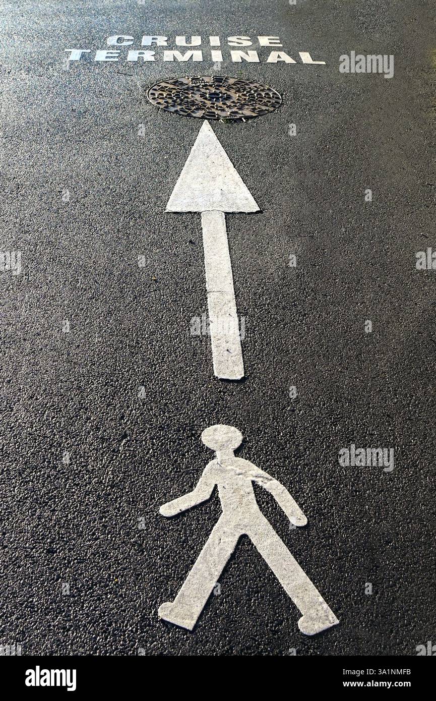 Simbolo e freccia su un marciapiede per mostrare ai pedoni la strada verso un terminal delle navi da crociera. Niente persone. Foto Stock