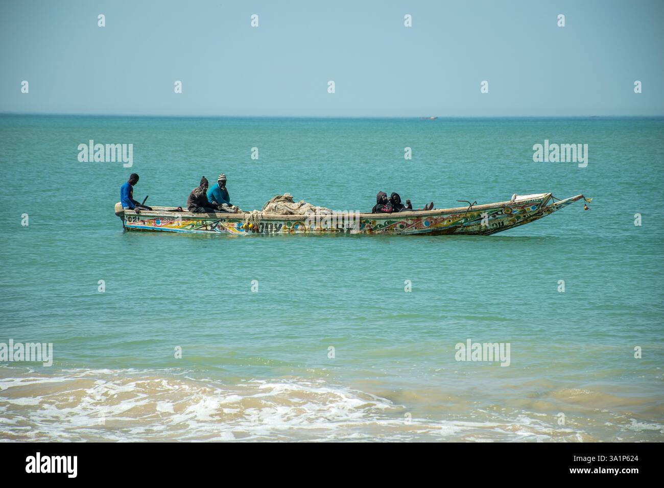 Pescatori artigianali su una canoa da pesca nell'oceano Atlantico in Senegal. Foto Stock