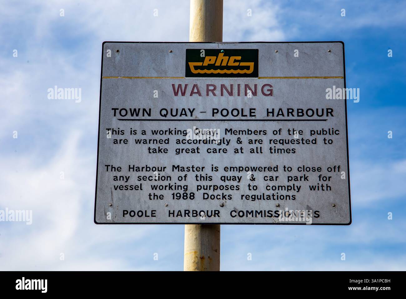 Cartello segnaletico per Town Quay Poole Harbour con informazioni sui regolamenti e le misure di sicurezza sotto un cielo azzurro Foto Stock