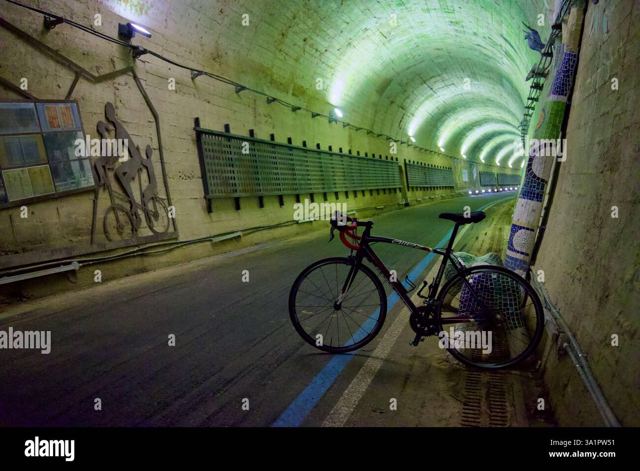 Contea di Sunchang, Corea del Sud - 4 ottobre 2021: Una bicicletta si appoggia contro un muro coperto di mosaico all'interno del tunnel Hyangga, un tunnel ferroviario riutilizzato sul fiume Foto Stock