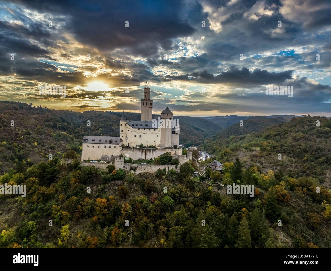 Vista aerea del castello medievale di Markburg sopra Braubach in Germania, con un alto che continua a salire sopra il suggestivo cielo del tramonto sul Reno Foto Stock