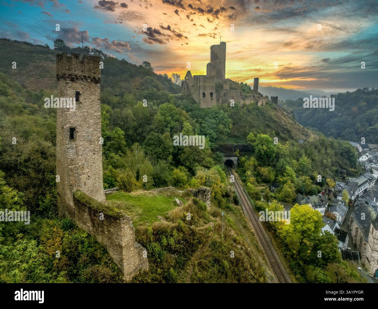 Vista aerea dei castelli gemelli di Philippsburg e Löwenburg sopra Monreal in Germania, con il cielo alto e maestoso del tramonto Foto Stock