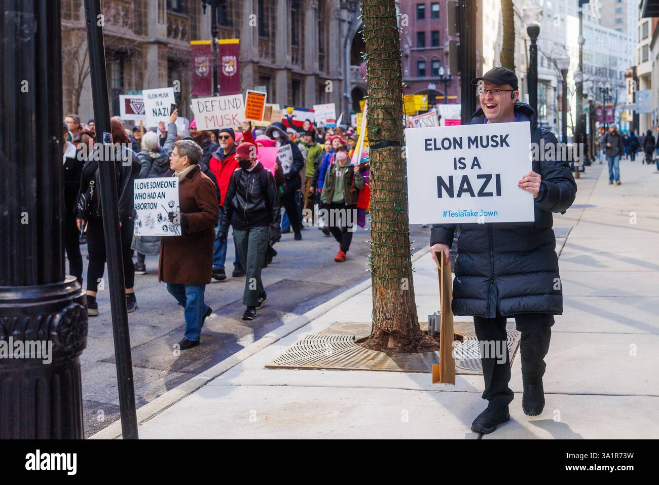 Chicago, Stati Uniti. 8 marzo 2025. Organizzati da diversi gruppi, tra cui Chicago indivisibile, i manifestanti nel centro di Chicago si sono riuniti e hanno marciato contro le politiche di Elon Musk e del presidente Donald Trump. Dopo i negoziati con la polizia di Chicago, ai manifestanti fu permesso di marciare verso la concessionaria Telsa a Rush Street. Centinaia di cantarono fuori dalle porte di Tesla contro Musk e DOGE. Crediti: JankPhoto/Alamy Live News. Foto Stock