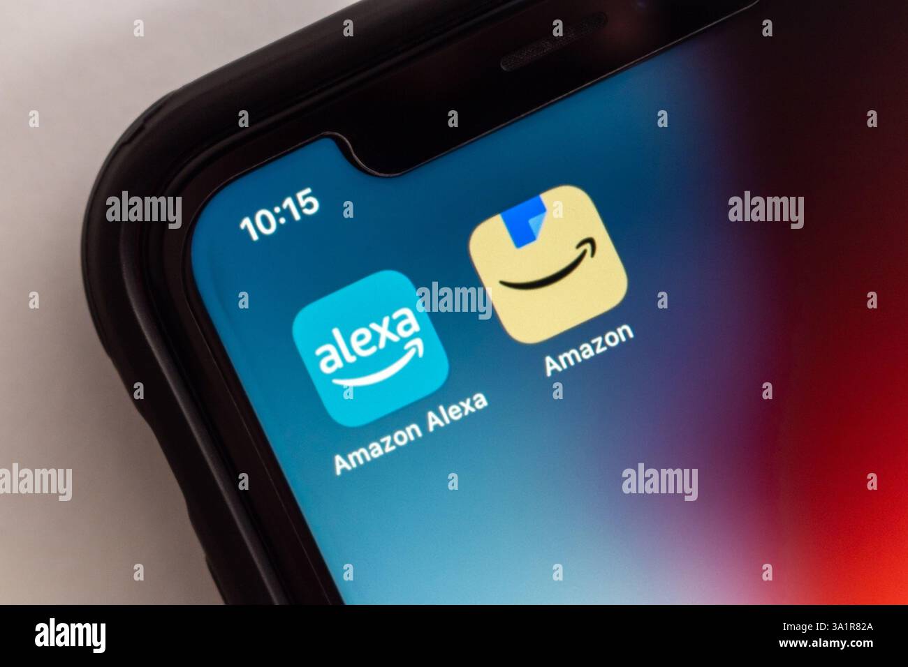 Le icone Alexa e Amazon vengono visualizzate sullo schermo di uno smartphone, che rappresenta l'ecosistema Amazon di assistenza vocale e tecnologia intelligente. Foto Stock