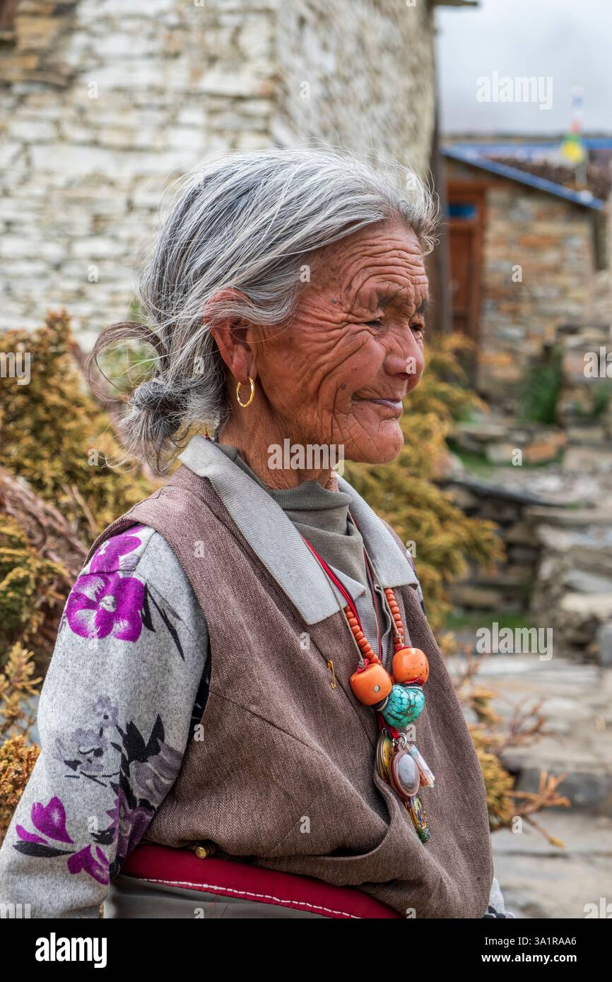 Una donna anziana posa nel villaggio di Nar, una delle aree ristrette del Nepal. Foto Stock
