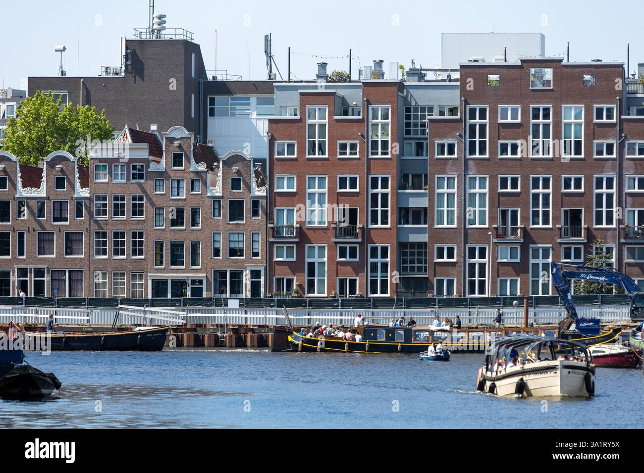 Facciate di edifici ad Amsterdam, storiche case in mattoni sul canale in fila. Foto Stock