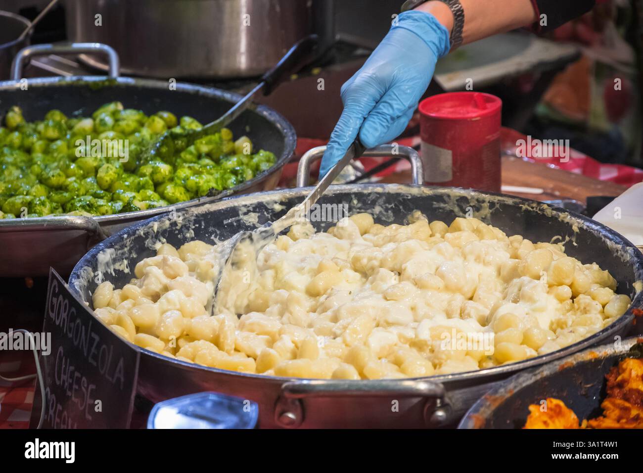 Gnocchi con cremosa salsa gorgonzola in mostra al Brick Lane Market di Londra, Inghilterra Foto Stock