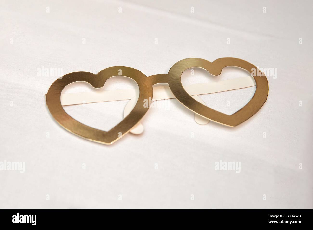 Occhiali a forma di cuore su sfondo bianco. Foto Stock