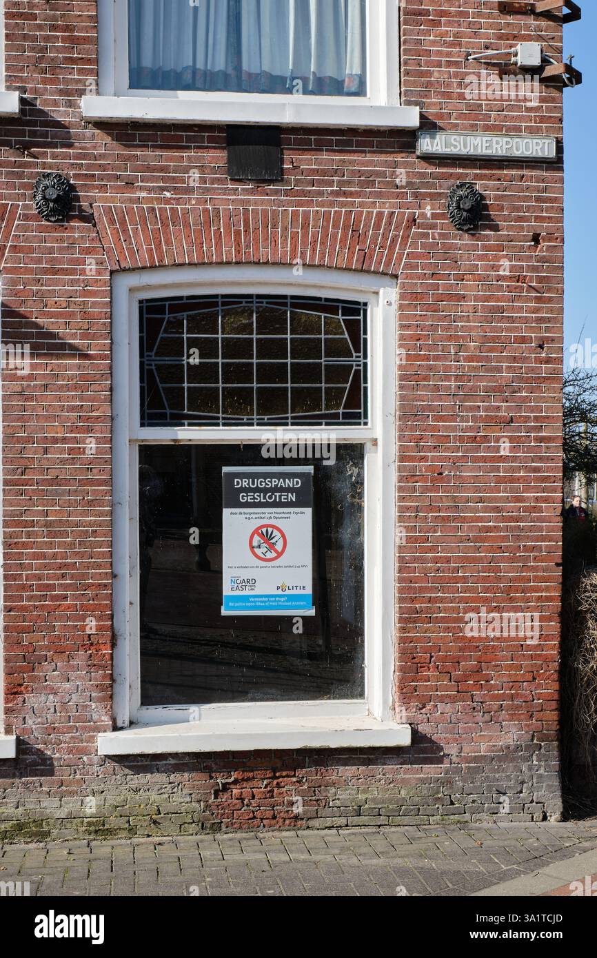 6 marzo 2025 - Dokkum, Paesi Bassi: Un edificio chiuso per ordine municipale a causa di attività legate alla droga, con un avviso di chiusura della polizia sul windo Foto Stock