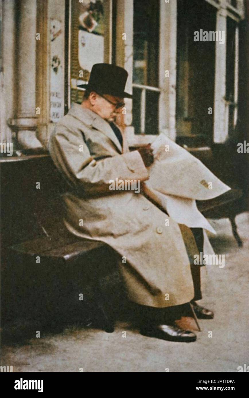 "Travelling Round Britain", 1940s, (1945). Il primo ministro britannico Winston Churchill legge un giornale mentre aspetta il suo treno in una stazione ferroviaria scozzese. Sir Winston Churchill (1874-1965) fu primo ministro del Regno Unito dal 1940 al 1945, e di nuovo dal 1951 al 1955. Da "The Life and Times of Winston Churchill", di Malcolm Thomson. [Odhams Press Limited, Londra]. (Stampa a colori in bianco e nero). Foto Stock