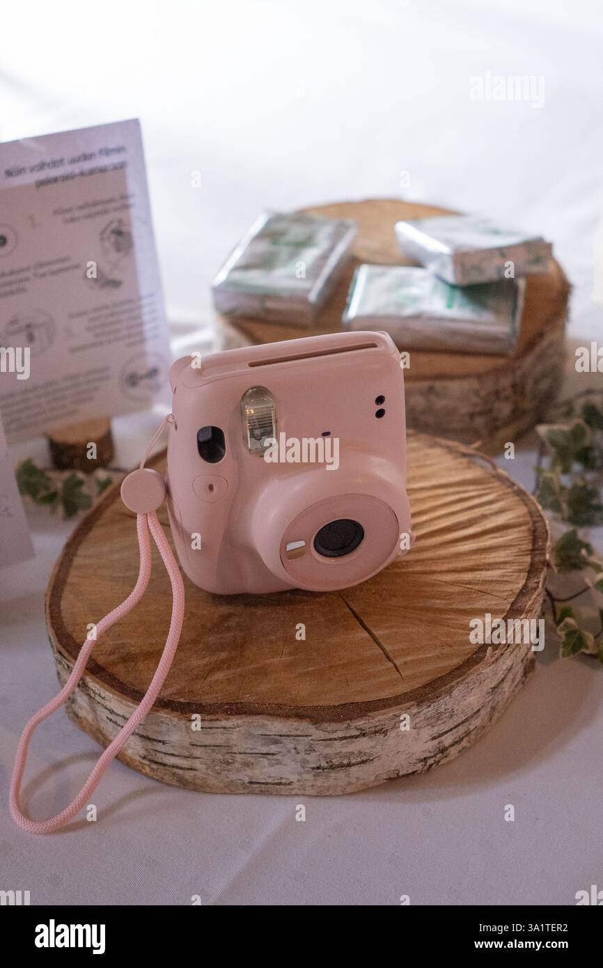 Fotocamera retrò su un piedistallo in legno con una confezione regalo sullo sfondo Foto Stock