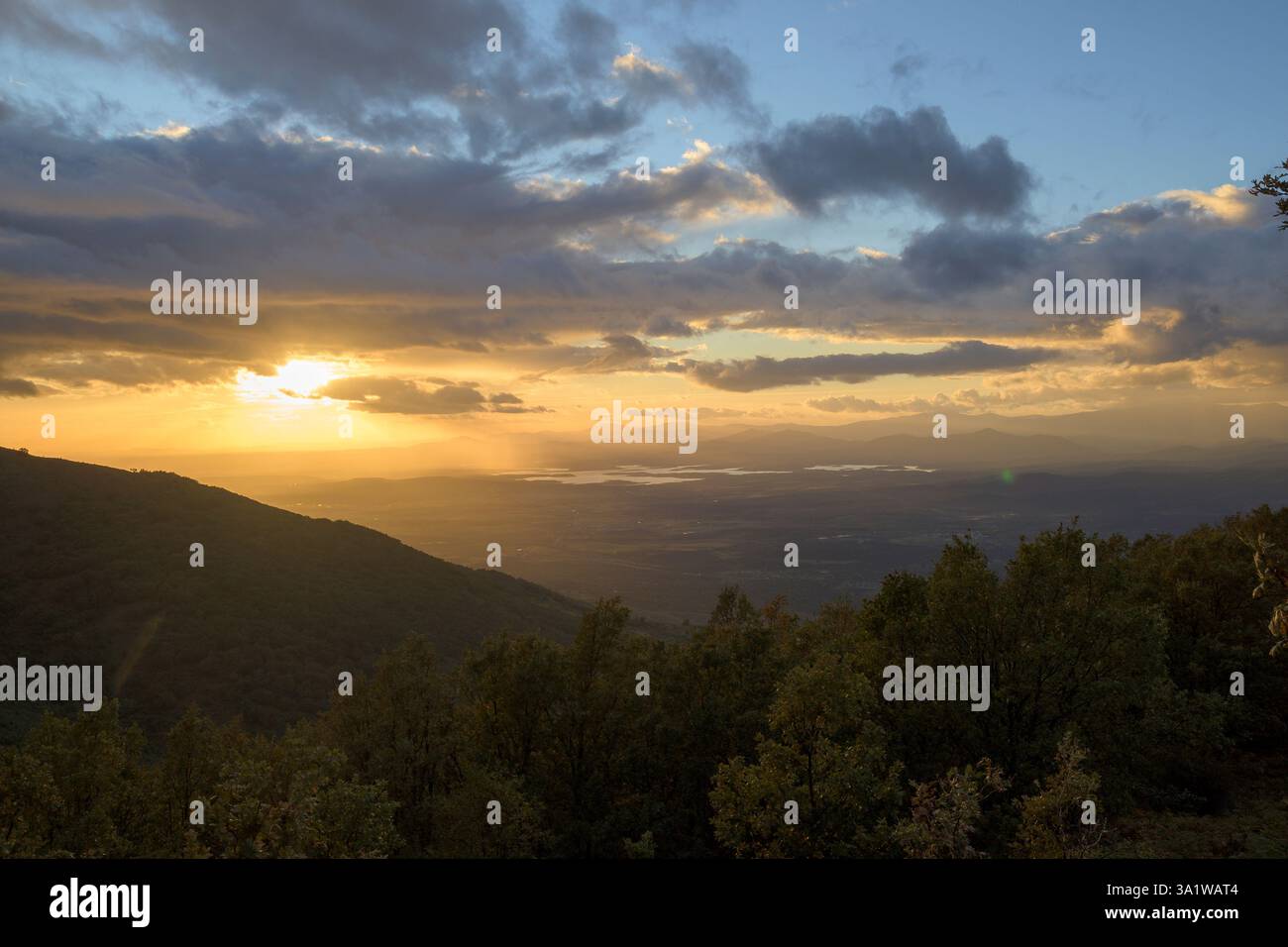 Tramonto con nuvole nel cielo blu con paesaggio montano tra gli alberi in HDR orizzontale Foto Stock Tramonto con nuvole nel cielo blu con paesaggio montano tra gli alberi in HDR orizzontale Foto Stock