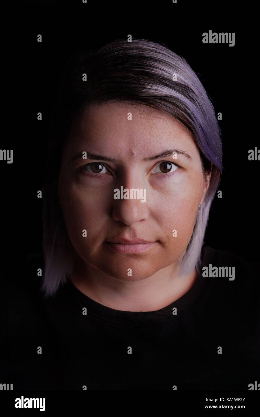 Ritratto in studio di una donna di 40 anni su sfondo nero. Foto Stock