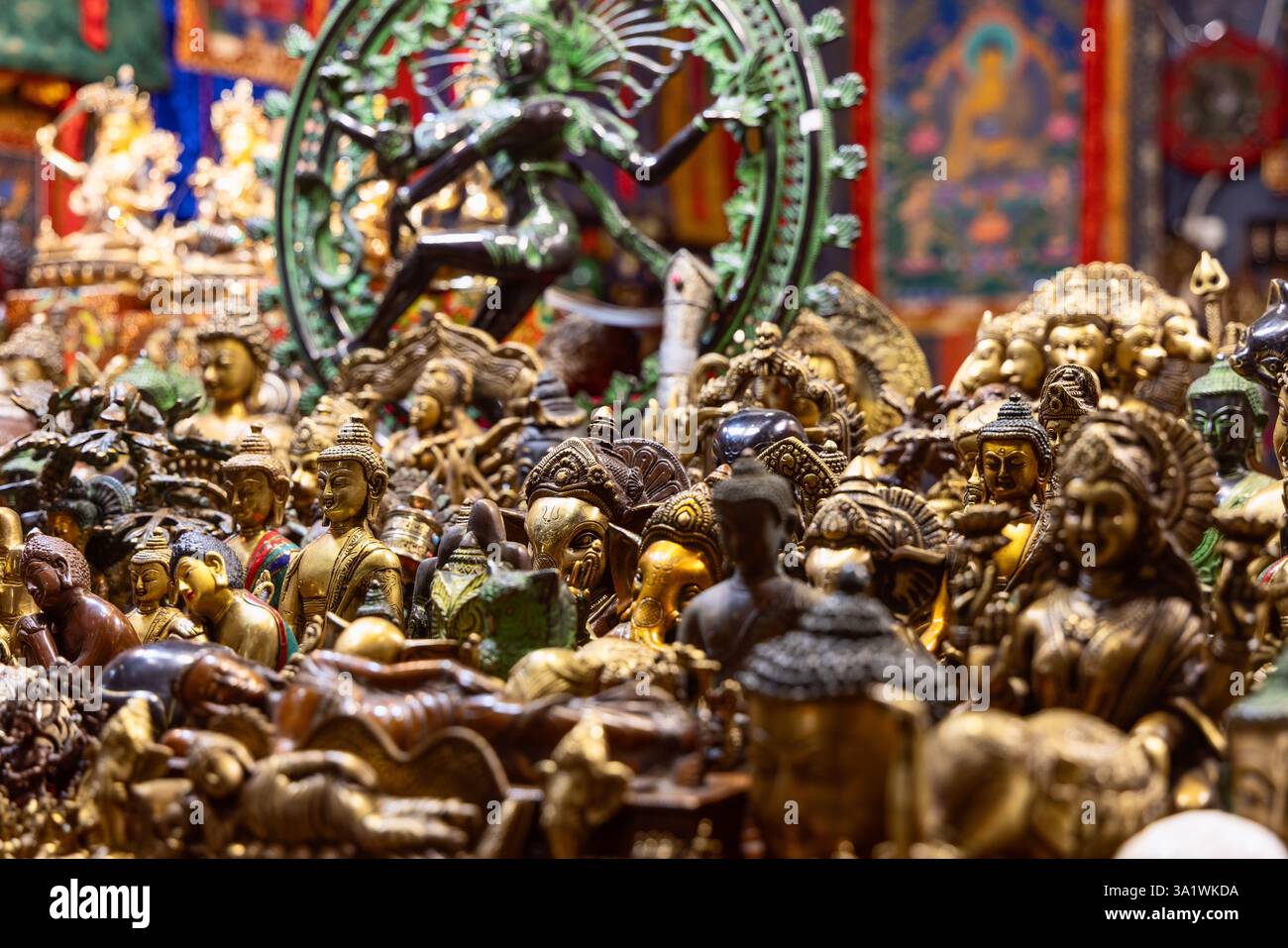 Collezione di sculture metalliche raffiguranti divinità indù e buddiste con ornamenti dettagliati e simboli religiosi collocati a stretto contatto in una traditiona Foto Stock