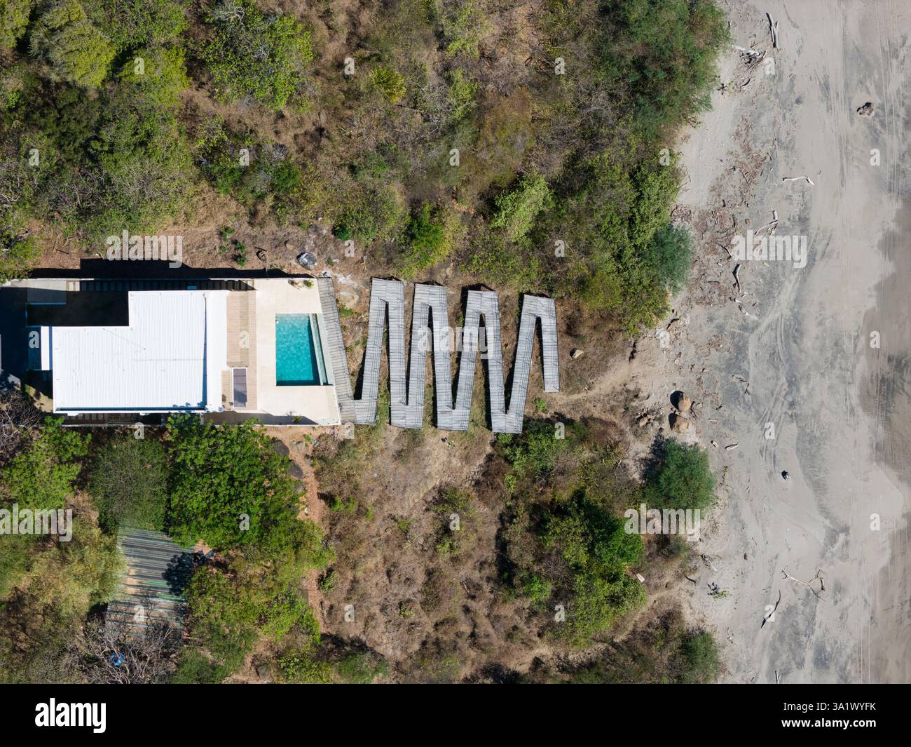 La villa contemporanea presenta piscina, sentieri e natura nelle giornate di sole vicino alla spiaggia. Foto Stock