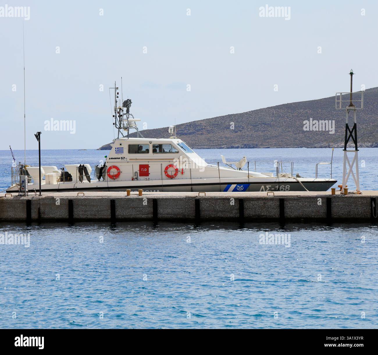 Porto di Livadia con barca della Guardia Costiera ellenica ormeggiata, isola greca di Tilos, Dodecaneso, Grecia. Preso maggio 2024 Foto Stock