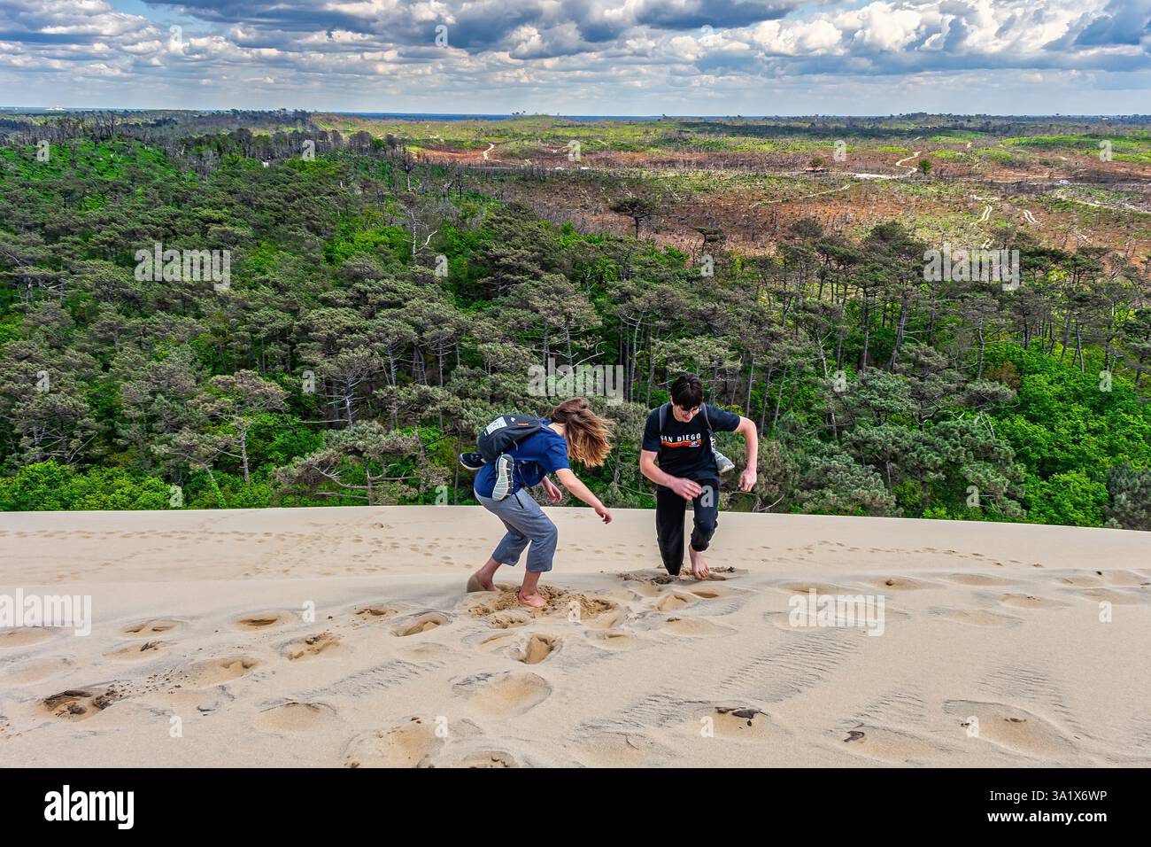 Due adolescenti giocano sulla Duna di Pilat, godendosi la vista panoramica delle acque turchesi della baia di Arcachon. Dipartimento ironde, Francia Foto Stock