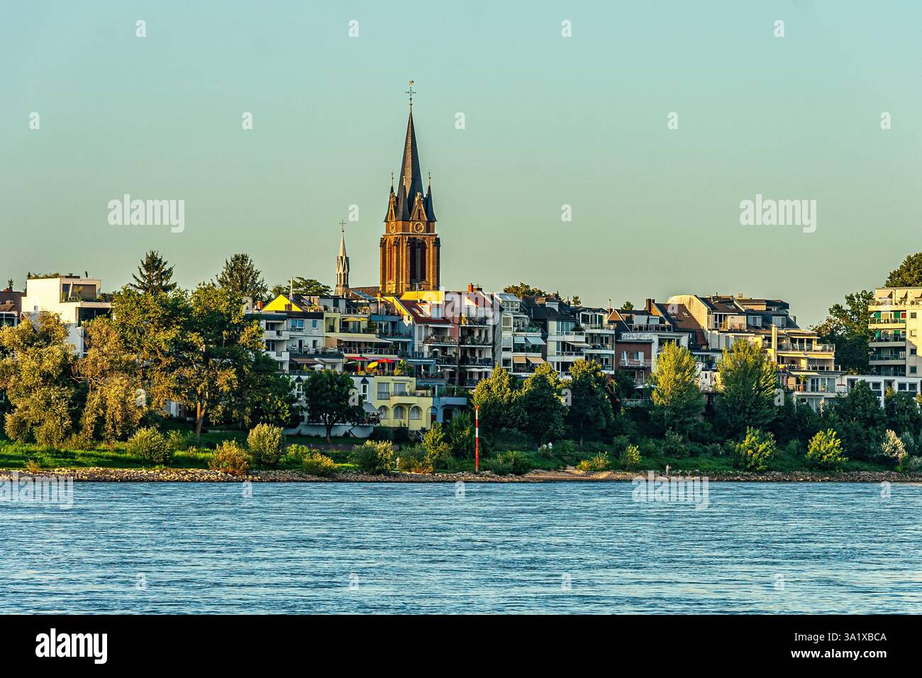 Il pittoresco quartiere di Ensen, caratterizzato dalla storica guglia della Chiesa di San Lorenzo, lungo le rive del Reno. Colonia, Germania, Europa Foto Stock