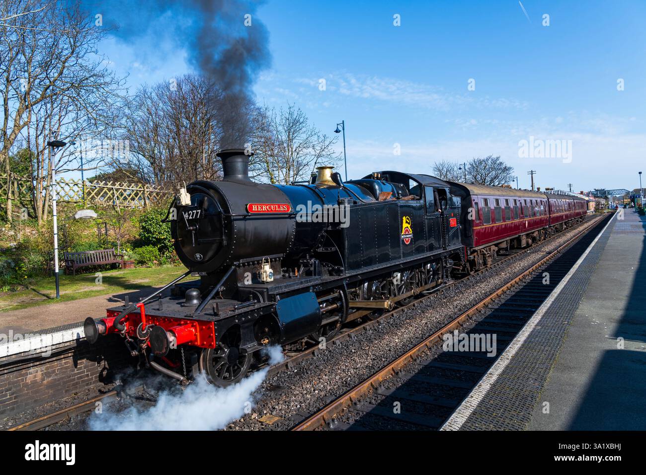 Sheringham, Norfolk, Regno Unito - 8 marzo 2025: Il treno a vapore Hercules parte dalla stazione di Sheringham a North Norfolk, Regno Unito, sulla Poppy Line Foto Stock