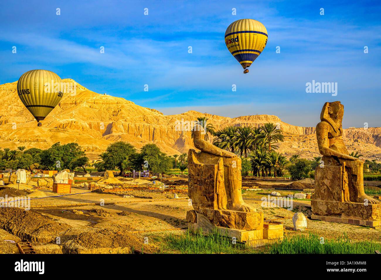 Mongolfiere che volano sopra le nuove statue di Amenhotep III nel sito di scavo dei Colossi di Memnone e del progetto di conservazione del Tempio di Amenhotep III Foto Stock