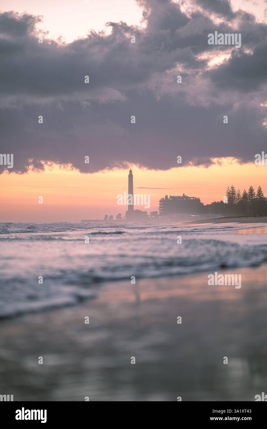 Romantico tramonto sul mare con un faro e nuvole tempestose Foto Stock