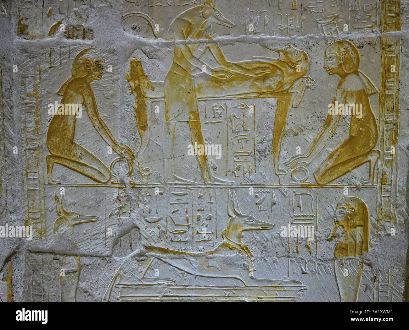 Il dio sciacallo Anubis che supervisiona l'imbalsamazione della mummia che giace su un bier Foto Stock