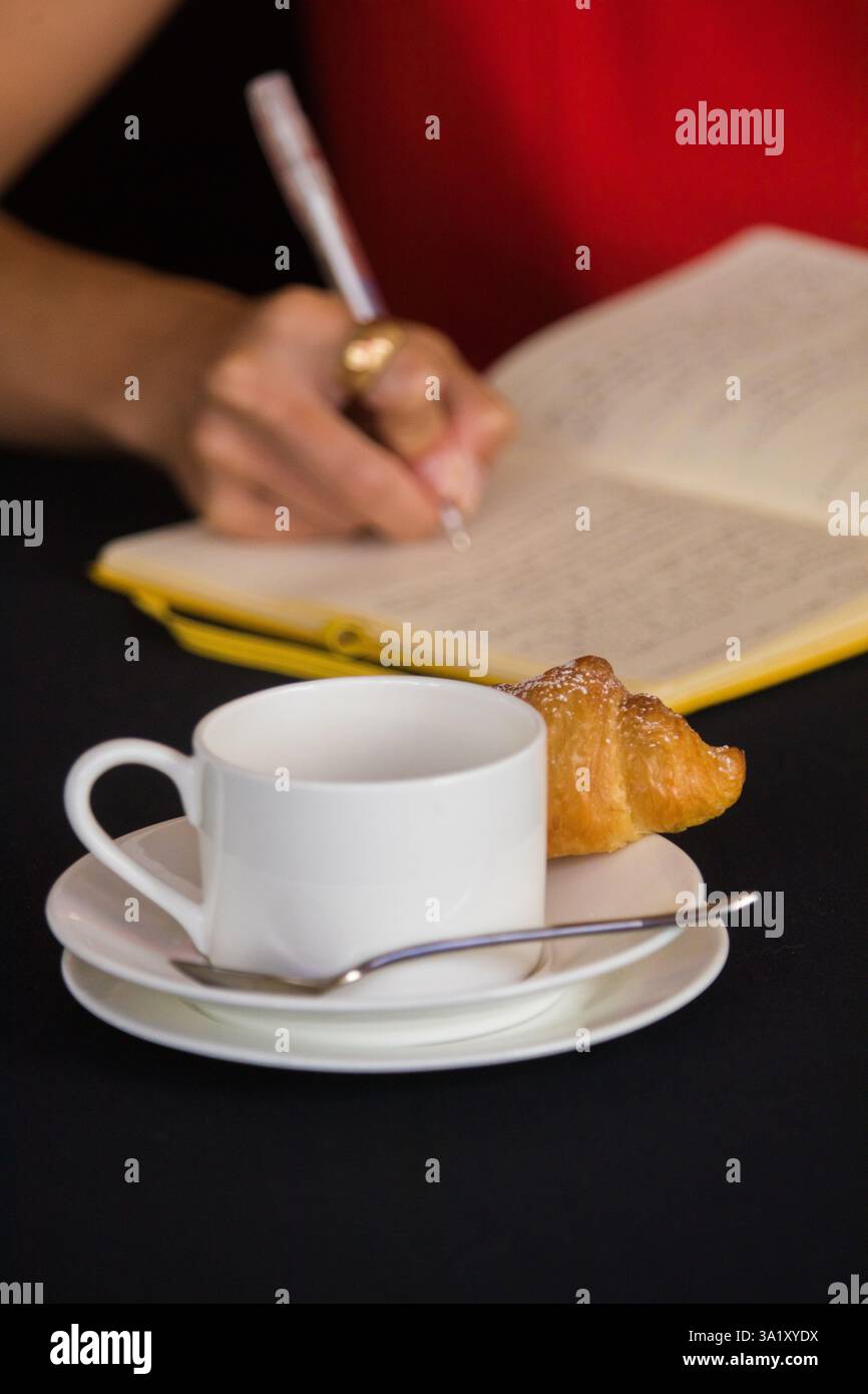 Persona che firma un libro degli ospiti in un bar Foto Stock