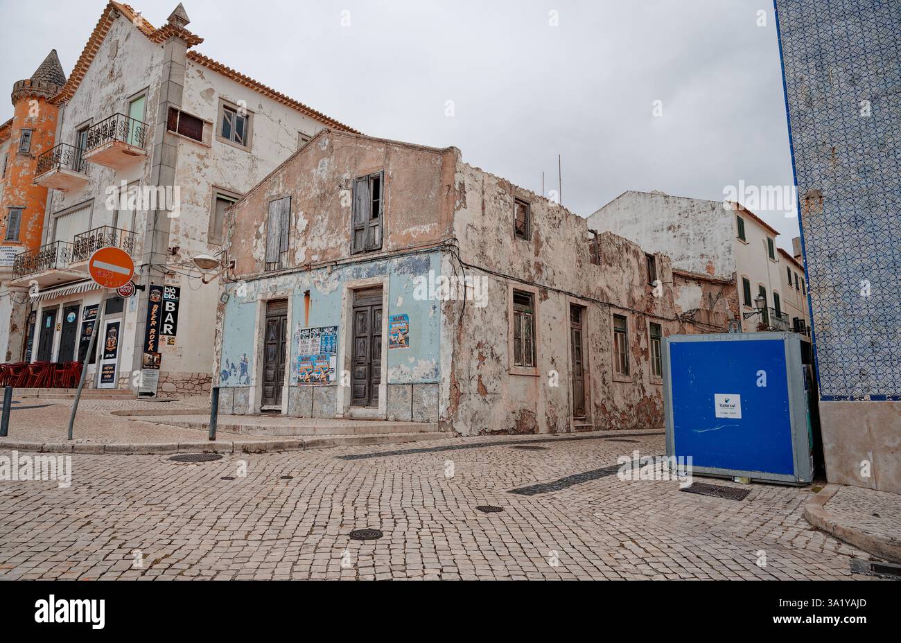 Un albergo abbandonato sul fronte spiaggia con pareti intemprate e vernice blu sbiadita Foto Stock