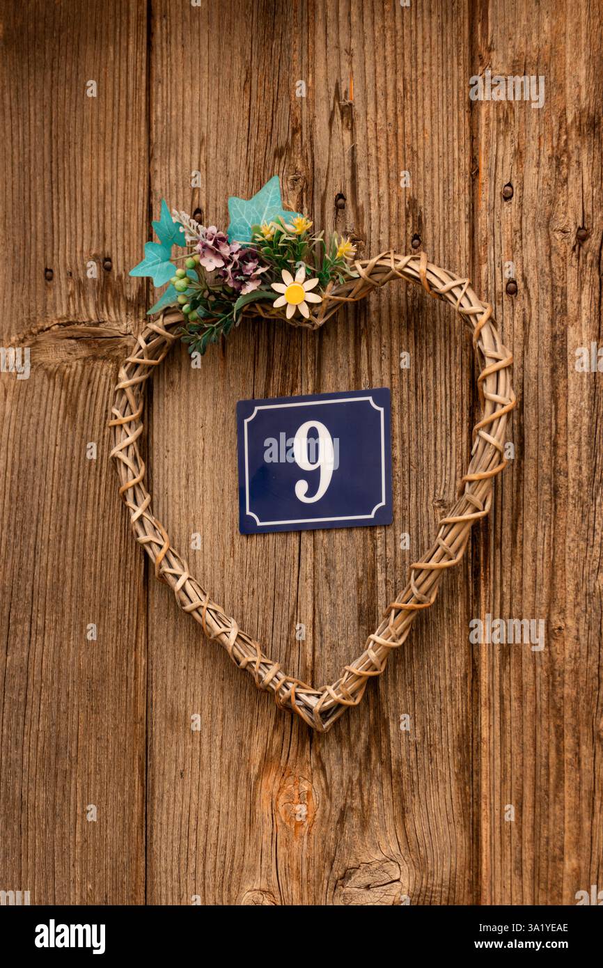 Casa numero 9 (nove) su parete in legno con struttura a forma di cuore Foto Stock